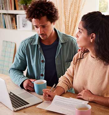 worried young couple in debt at home with laptop